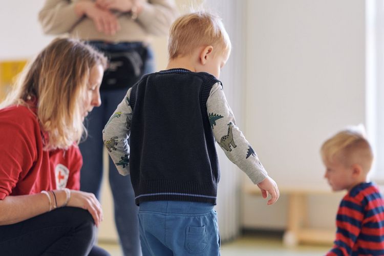 Man sieht Kinder und eine Erzieherin.