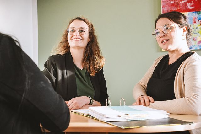 Beratungssituation von drei Personen an einem Tisch