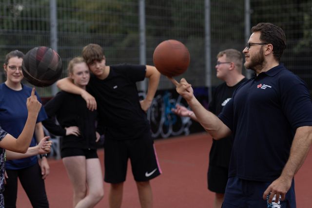 Jugendliche auf Basketballplatz.