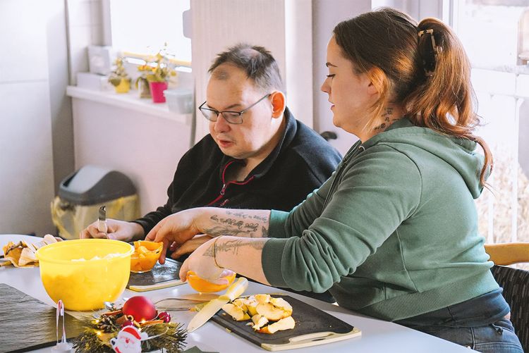 Gemeinsam bereiten Mitarbeiter und Bewohner Essen zu.