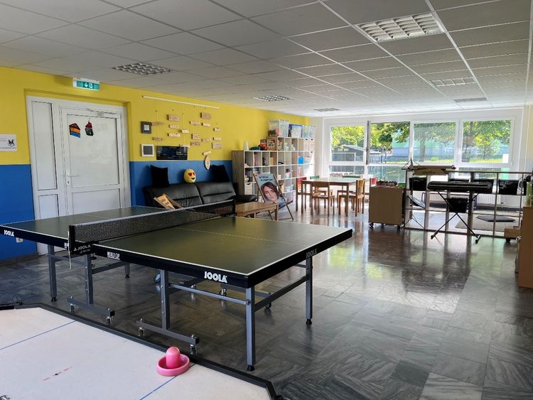 Ansicht eines großen Raumes mit Tischtennisplatte aus dem Juniorclub 30 Freunde.