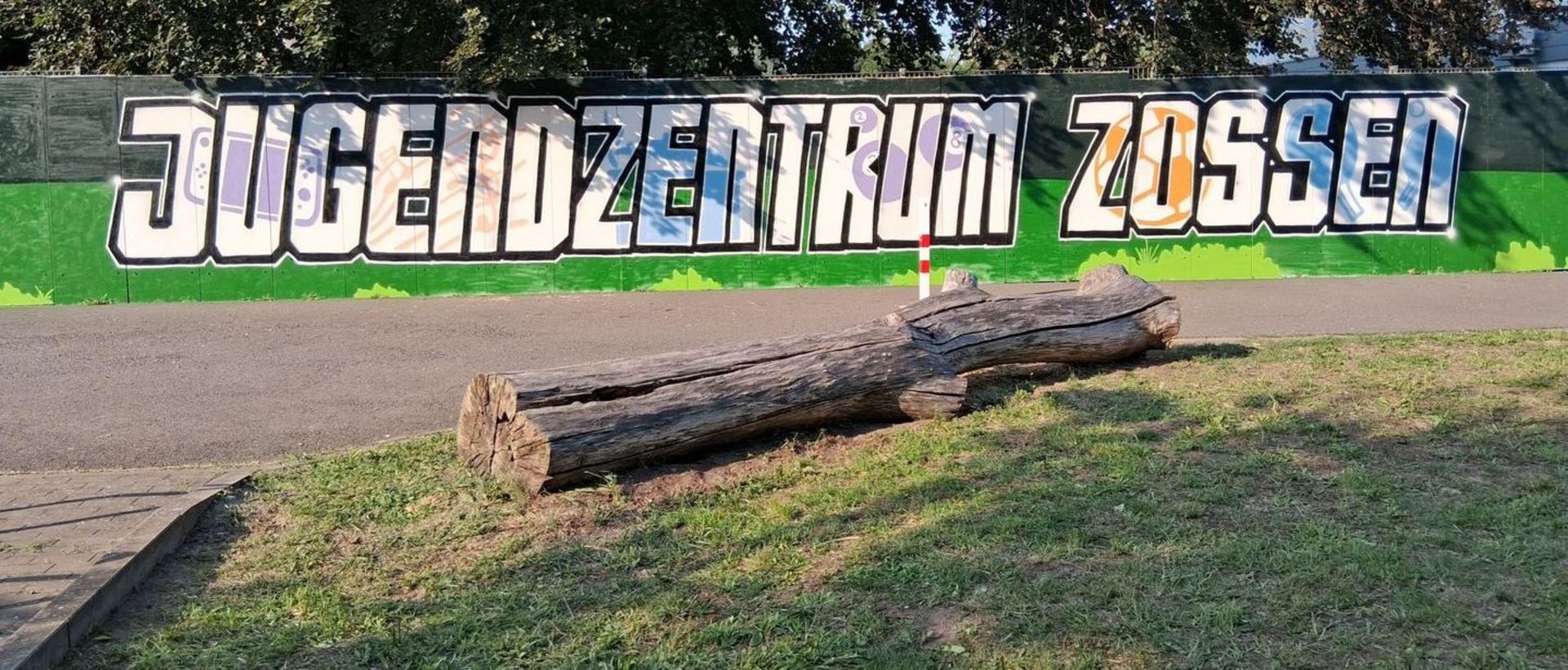 Man sieht ein durch Graffiti gestaltetes Banner mit Schriftzug "Jugendzentrum Zossen"