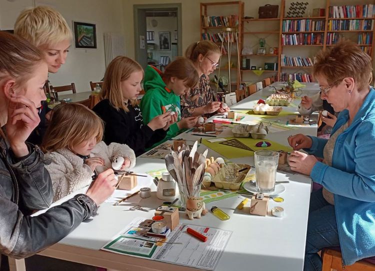 Verschiedene Generationen an einem Tisch beim Basteln.