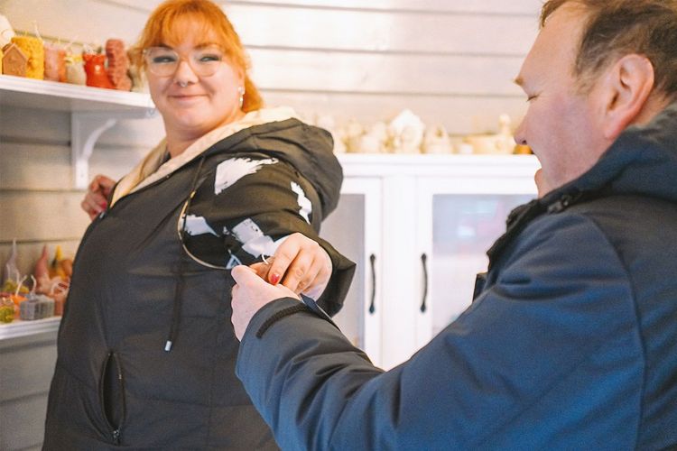 Mitarbeiterin reicht einem Nutzer ein selbst hergestelltes Objekt, welches im Schlösschen seinen Platz finden soll.