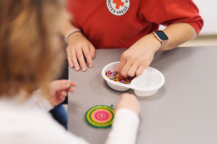 Gemeinsam wird ein Bild aus Bügelperlen hergestellt.