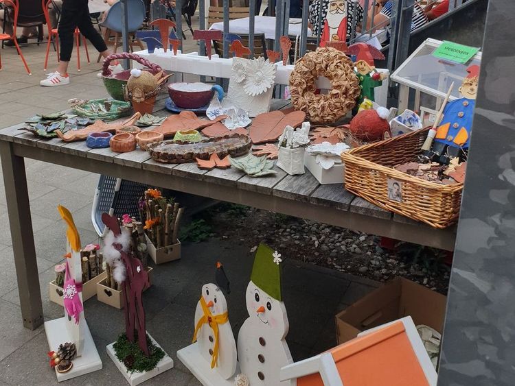 Das Bild zeigt einen Tisch, auf welchem in der internen Tagesförderung hergestellte Werke ausgestellt sind.