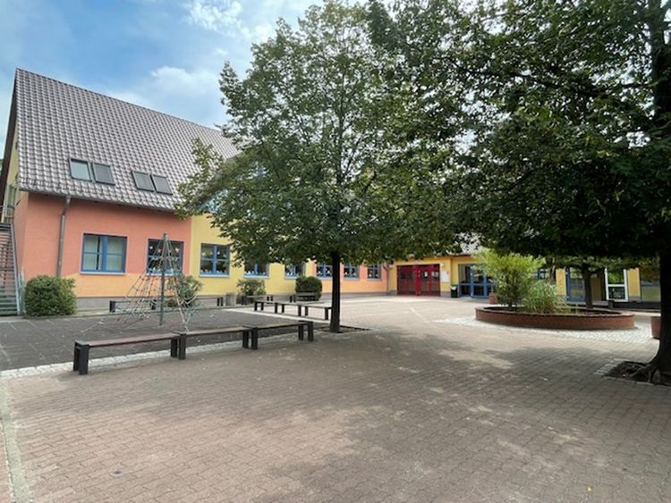 Ansicht des Schulgebäudes inklusive Schulhof.