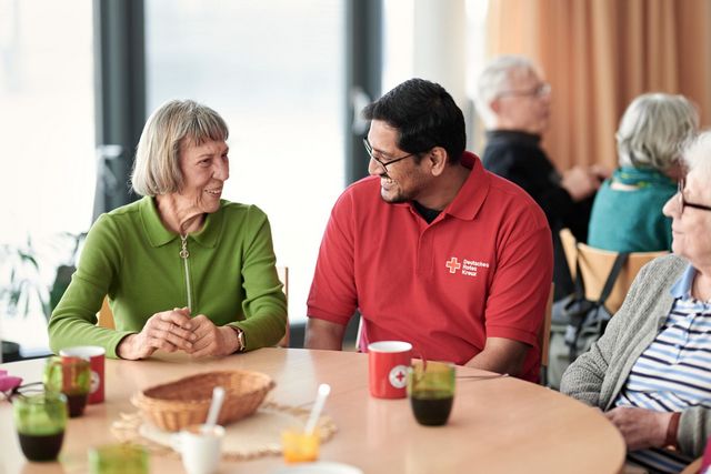 Ein Herr im netten Gespräch mit einer Seniorin.