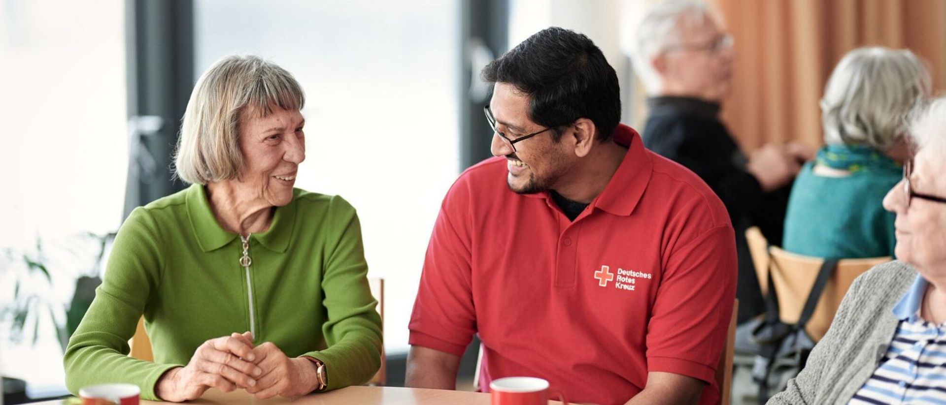 Ein Herr im netten Gespräch mit einer Seniorin.