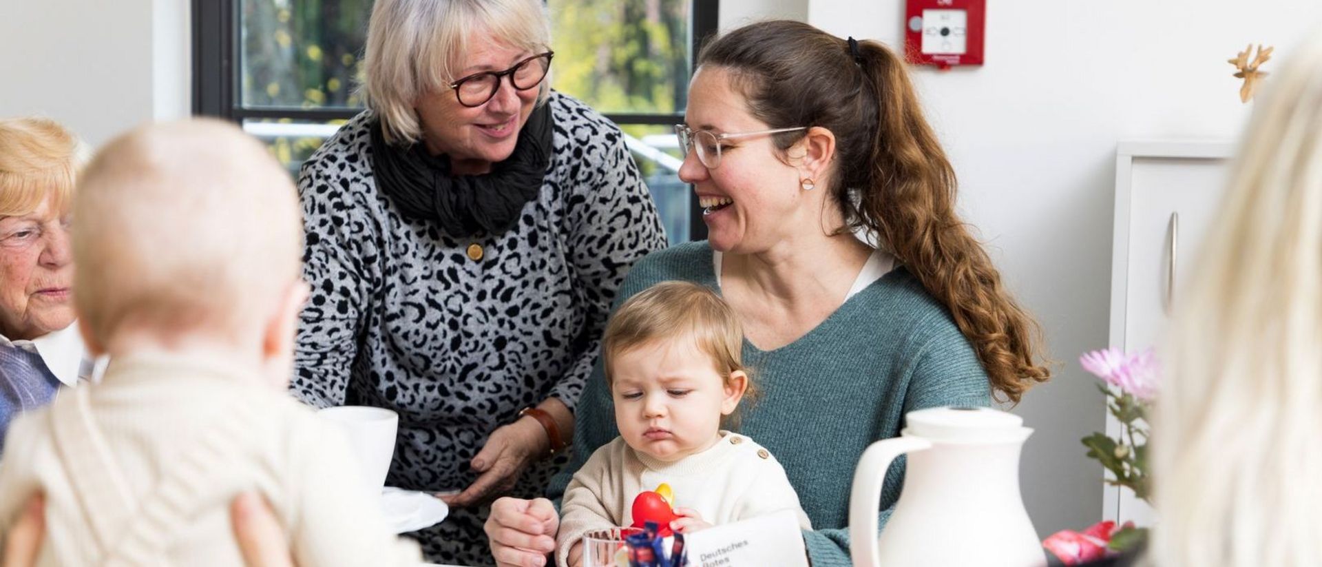 Verschiedene Generationen sitzen gemeinsam am Tisch bei Kaffee und Kuchen.