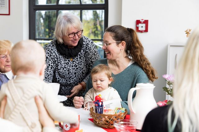 Verschiedene Generationen sitzen gemeinsam am Tisch bei Kaffee und Kuchen.