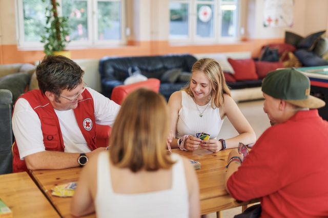 Vier Personen spielen Karten im Jugendzentrum.