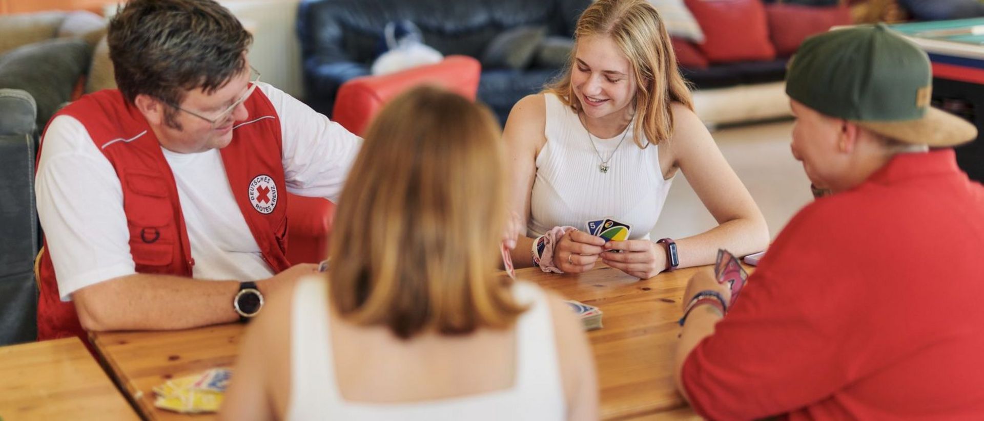 Vier Personen im Jugendzentrum spielen gemeinsam Karten.