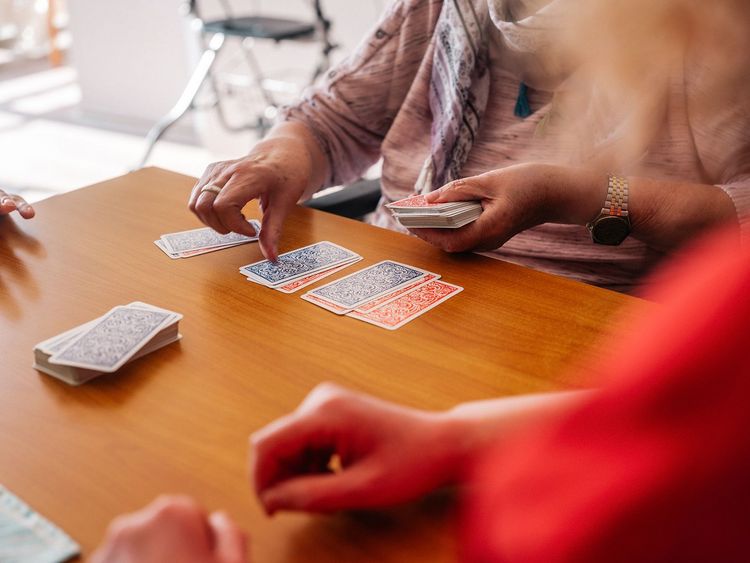 Man sieht eine Detailansicht von einem Kartenspiel zwischen zwei Damen.