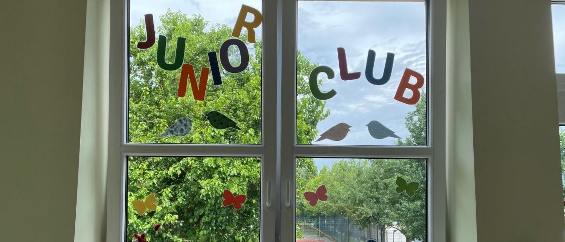 Ein Fenster, dekoriert mit Buchstaben, welche "Juniorclub" ergeben.