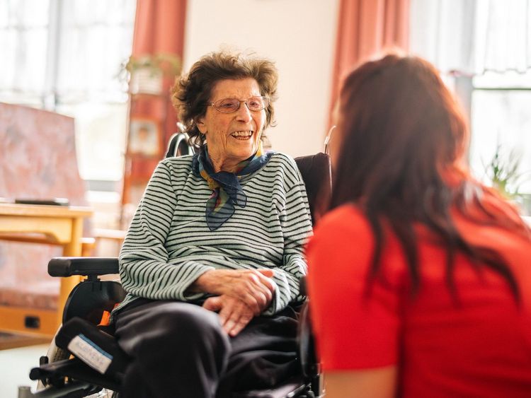 DRK Mitarbeiterin unterhält sich mit Seniorin.