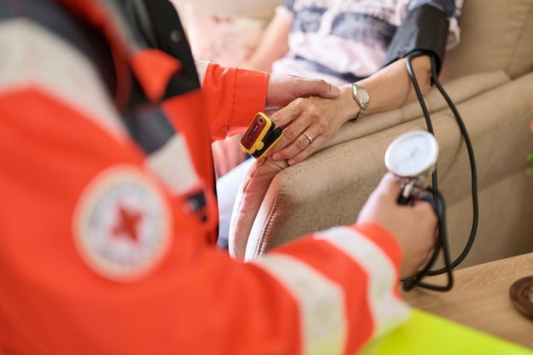 DRK Mitarbeiter misst Blutdruck.