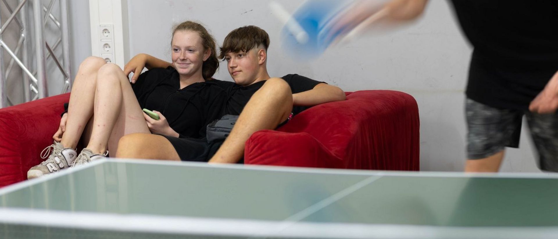Jugendliche sitzen auf Couch.